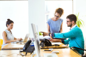 Three professionals working in an office, each at their computer